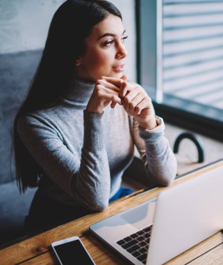 Wifi bağlı dizüstü bilgisayar üzerinden tabii dil online kırmak pencerede pencereye bakarak Dreaming hipster kız, pensive freelancer netbook ile ahşap masada oturan çatı iç kafede zaman zevk