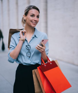 Kara Cuma satışları sırasında alışveriş yapmak için güzel bir gün geçiren kaygısız genç bayan renkli kese kağıtlarıyla çekici gülümseyen hippi kız şehir ortamını beklerken gözlerini kaçırıyor.