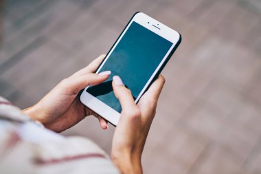 Sokakta yürüyen 4G internet bağlantısını kullanarak modern akıllı telefon cihazının ekranında yazı yazan kadınların üst kesitli görüntüsü. Kadınlar sosyal ağlarda cep telefonlarıyla sohbet ediyorlar.
