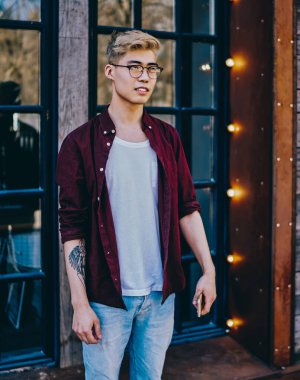 Zarif optik gözlüklü yakışıklı hippi gözlüklü, şık giyinmiş, rahat şehir ortamında duran ve boş zamanlarında ileriye bakan şık giysili gözler için koruma sağlıyor.