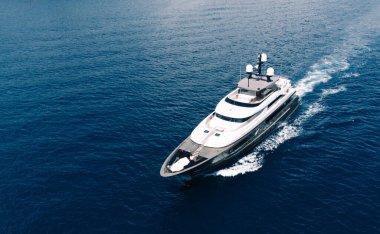 Aerial view of luxury yacht goes to open sea with beautiful blue colour of water. Wealth recreation lifestyle. Birds eye view of expensive floating ship traveling by Europe in summer clipart