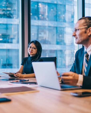 Başarılı erkek ve kadın meslektaşlar iletişim kuruyor ve ofis içi iş birliği yapıyor masada oturuyor ve fikirleri tartışıyor. Bir grup şirket çalışanı finansal strateji planlaması yapıyor.