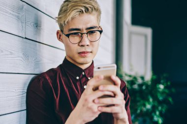 Görme düzeltmesi için optik gözlük takan ciddi Japon erkek blogcu, kapalı alanlarda ücretsiz internet bağlantısı kullanarak akıllı telefon uygulaması tebligatı hakkında aldığı e-postada şaşkın hissediyor