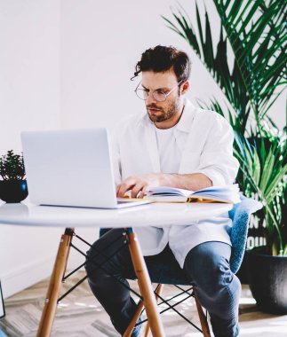 Uzaktan kumandalı optik gözlüklü ciddi bir işçi işe odaklanmış. Başlangıç projesini planlamak için ekipmanla masada oturuyor. Genç adam dizüstü bilgisayarla kendi dairesinde vakit geçiriyor.