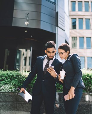 Konsantre erkek ve kadın çalışanlar, finans bölgesindeki kamu kablosuz ağına bağlı olarak şirket müdüründen e-posta aldılar, iş ortakları cep telefonlarıyla çevrimiçi sohbet ediyorlar.