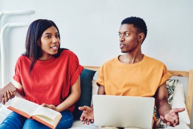 Genç üzgün Afrikalı çift evde yatakta oturan ilişkilerle ilgili tartışırken, evlilik anlaşmazlıktan rahatsız olurken, boş zamanlarını parlak dairelerde geçirmekte zorlanıyor.