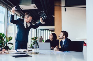 Erkek patronun şirket çalışanlarıyla toplantı sırasında rapor istatistikleriyle ilgili sorunları çözmesi, girişimcilerin konferans odasında oturup müdürün konuşmasını dinlemesi. Erkekler konuşuyor