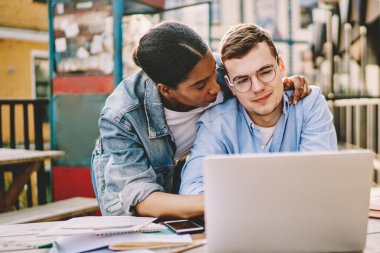 İnternetten alışveriş yapmayı seven bir çift laptopla birlikte bakınıyor. Afrikalı Amerikalı bir kadın sevgilisine sarılıyor. İnternette netbook 'la birlikte oturduğu için çok memnun.