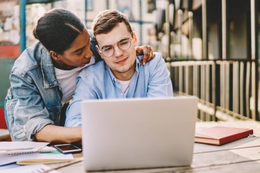 İnternetten alışveriş yapmayı seven bir çift laptopla birlikte bakınıyor. Afrikalı Amerikalı bir kadın sevgilisine sarılıyor. İnternette netbook 'la birlikte oturduğu için çok memnun.