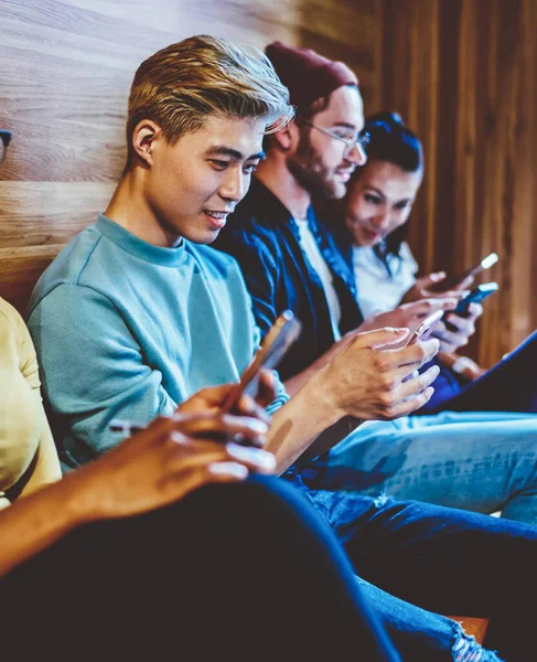 Multicultural hipster bloggers chatting with virtual friends on modern smartphones using free 4G internet connection.Diverse young people from millennial generation addicted from social networks