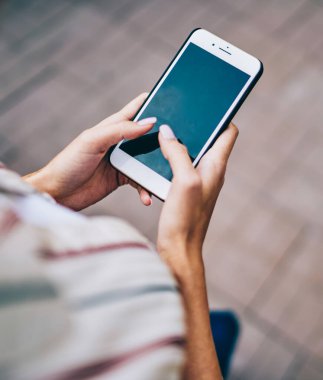 Sokakta yürüyen 4G internet bağlantısını kullanarak modern akıllı telefon cihazının ekranında yazı yazan kadınların üst kesitli görüntüsü. Kadınlar sosyal ağlarda cep telefonlarıyla sohbet ediyorlar.