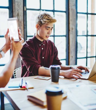 Japon hipster adam internete girmek için kablosuz bağlantı kullanarak iletişim için en iyi uygulamalar hakkında bilgi ararken cep telefonuyla selfie çeken bir bayan arkadaş...