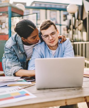 İnternetten alışveriş yapmayı seven bir çift laptopla birlikte bakınıyor. Afrikalı Amerikalı bir kadın sevgilisine sarılıyor. İnternette netbook 'la birlikte oturduğu için çok memnun.