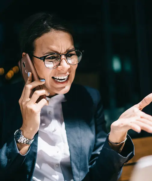 Görme düzeltmesi için optik gözlüklü kızgın kadın dizüstü bilgisayarla şirket muhasebe raporuyla e-posta aldı ve şirket müdürünü bağırıp çağırarak öfkeden kudurdu.