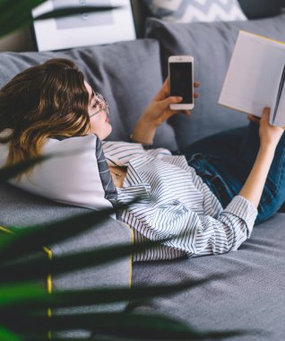 Akıllı genç kadın rahat bir kanepede uzanıyor ve kendi odasında ilginç kitaplar okuyor. Akıllı hippi kız elinde telefon tutuyor ve boş zamanlarında koltukta dinlenerek en çok satan kitaplardan hoşlanıyor.