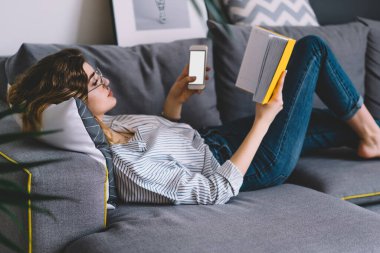 Kanepede uzanan ve edebiyat kitabı okuyan genç bir kadın boş ekranla akıllı telefondan e-postayı kontrol ediyor. Hippi kız cep telefonundan mesaj gönderiyor ve en çok satan kitaplardan keyif alıyor.