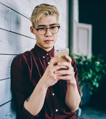 Görme düzeltmesi için optik gözlük takan ciddi Japon erkek blogcu, kapalı alanlarda ücretsiz internet bağlantısı kullanarak akıllı telefon uygulaması tebligatı hakkında aldığı e-postada şaşkın hissediyor