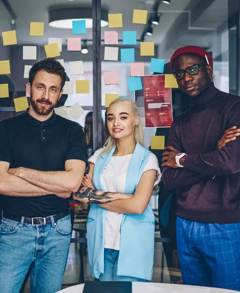 Half length portrait of male and female multiracial team members standing together at coworking office, prosperous diversity group of business colleagues looking at camera ready for productive job