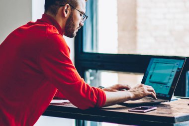 Genç bir erkek, yeni web sitesi için program kodu oluşturulurken dizüstü bilgisayardaki internet bağlantısı hakkında sağlayıcısından online müşteri hizmetleri ile iletişim kuruyor.