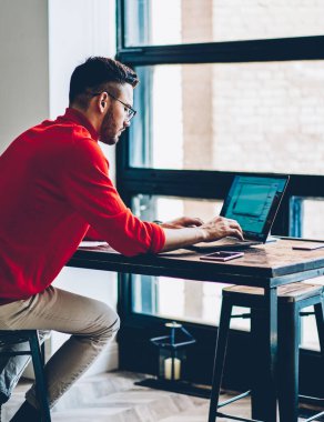 Genç bir erkek, yeni web sitesi için program kodu oluşturulurken dizüstü bilgisayardaki internet bağlantısı hakkında sağlayıcısından online müşteri hizmetleri ile iletişim kuruyor.