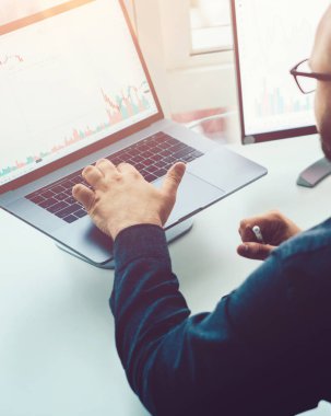 Ofis masaüstü bilgisayarlarında mali grafikleri ve monitörle ilgili istatistikleri olan iş adamlarının arka planı. Araştırma, dijital pazar analizi ve blok zincirindeki yatırımın analizi.