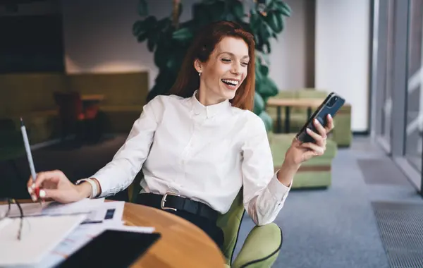 Щаслива Жінка Підприємець Офіційному Одязі Сидячи Столом Документами Переглядаючи Телефон — стокове фото