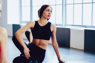 Sağlıklı merkezde vücut içi planlama egzersizi yapan mutlu fitness kadını, pilates yapan zayıf kızlar spor salonunda egzersiz yapıyor, sağlıklı yaşam tarzı motivasyonu ve spor stüdyosu konsepti.
