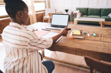 Taşınabilir bilgisayar notları ile odaklanmış siyah kız öğrencinin arka planı renkli kalemle işaretleme notları ile evden öğrenirken