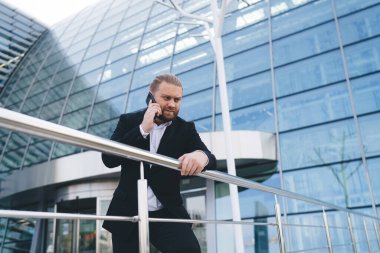 Siyah takım elbiseli genç ve modern iş adamlarının ofis binasında konuşurken ciddi konuşmaları.