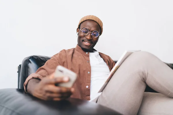 Pozitivní Afroameričan Mladý Muž Brýlích Relaxační Pohovce Při Pohledu Obrazovku — Stock fotografie