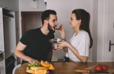 Mutlu Kafkasyalı eş, evinde kahvaltıda birlikte yemek yediği için kocasına kaşıkla yemek veriyor. Salata tabağı taşıyan kaygısız kadın, vejetaryen sevgilisine sebze veriyor.