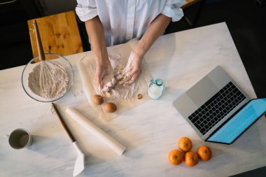 Serbest bir proje üzerinde çalışırken ve evde mutfaktaki masada netbook kullanırken ekin üreten kadınların kurabiyelerinin en üst görüntüsü