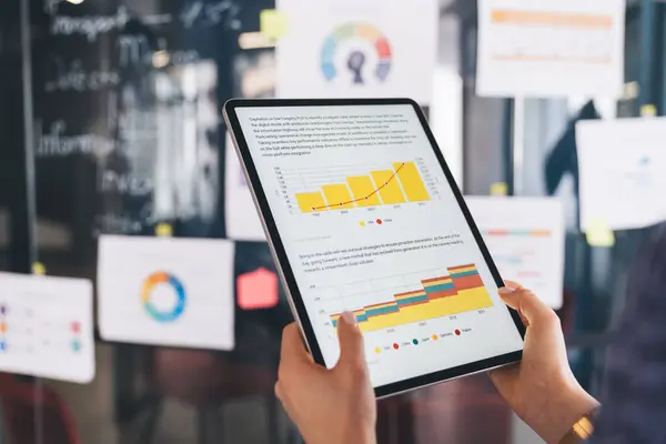 Cropped female boss analyzing revenue graph charts displayed on modern touch pad during working time in office, unrecognizable businesswoman browsing infographics via application on digital tablet