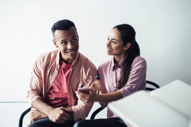 Elinde akıllı telefon cihazıyla neşeli yeniyetme kız tatilde erkek meslektaşlarıyla canlı iletişimde eğleniyor. Cep telefonu ve ders kitabından gelen bilgileri tartışan bir grup mutlu insan.
