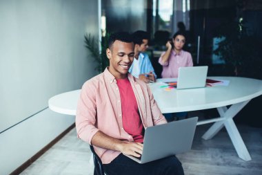 Mutlu milenyum erkeğinin internet sitesinde internet gezmek için 4G kablosuz bağlantısıyla online rezervasyon yapması, modern dizüstü bilgisayarda online iletişim sırasında bilgi arayan neşeli bir adam.