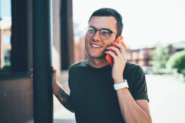 Gözlüklü genç, gözlüklü, arkadaşlarıyla akıllı telefon iletişiminin keyfini çıkaran, açık havada gezen, gözlüklü, mutlu genç adam cep telefonu uygulaması üzerinden arıyor.