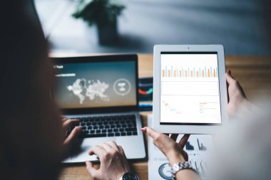 Renkli çizelgelerle tableti gösteren ekin dişisinden, masadaki yüzü olmayan patrona, bilgisayarında dünya haritasını gösteren bir bilgisayarla ofiste.