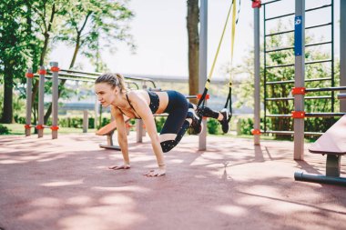 Spor kıyafetleri içinde kendine güveni tam bir bayan. Spor alanında el üstünde antrenman yaparken askıya alınma eğitimi alıyor.