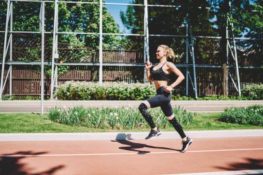 Genç sporcu bayan sporcunun yeşil parkta spor yaparken aktif yaşam tarzının keyfini çıkarması ve egzersiz yapması.
