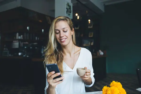 Charming Caucasian Female Blogger Using Mobile Phone Sending Message While Стокове Зображення
