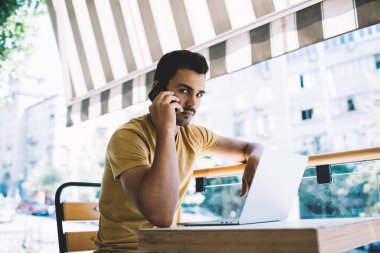 Kafkas erkek serbest çalışan, kafeterya terasında çalışırken akıllı telefon görüşmesi yapan, kendine güvenen adam milenyumu operato ile cep telefonu konuşmalarına odaklandı.