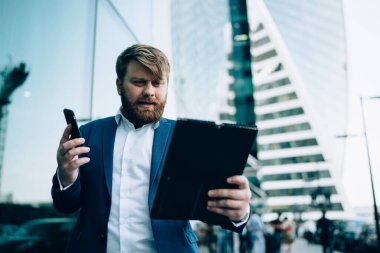 Şık elbiseli dalgın işadamından. Belgelere odaklanıyor ve şehir merkezindeki telefon görüşmelerini analiz ediyor.