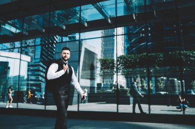 Aşağıda sakin, kendine güvenen, ceketli, omuzları üzerinde şık bir yönetici var. Uzaklara bakıyor ve ayna karşısında gökdelenlerin yansımalarıyla yürürken hayal kuruyor.