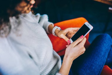 Ekin bayanın üstünden bacak bacak bacak üstüne atarak sosyal medya mesajlarını kullanarak kafede mobil dinlenme üzerine sohbet ederek. 