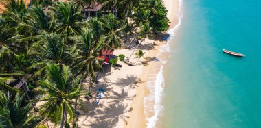 Turkuaz su dalgaları ve yeşil tropikal palmiyelerle dolu pitoresk kıyı şeridi manzarası. Hawaii kıyılarında teknesi olan cennet manzaralı bir sahil. Yaz tatili için gidilecek yer. 