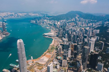 Hong Kong gökdelenlerinin insansız hava aracının panoramik manzarası Metropolitan körfezi ile gökdelenlerin ufuk çizgisi. Şehir merkezinde iş ve finans binaları olan modern beton şehir manzarası. Şehir altyapısı