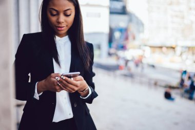 Ciddi, zarif, Afro-Amerikan bayan resmi olarak New York 'un caddesinde cep telefonuyla mesajlaşarak vakit geçiriyor. 