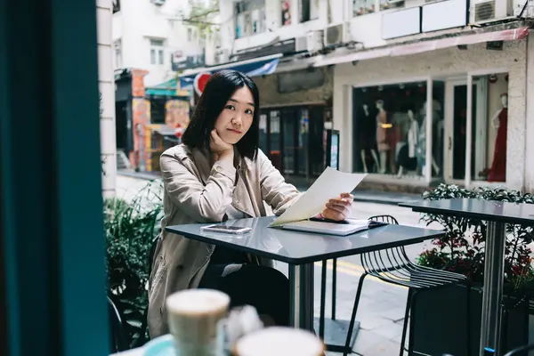 Chytrá Asijská Žena Zamyšleně Dívá Fotoaparát Při Práci Papírem Čtení — Stock fotografie
