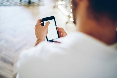 Yüzsüz, beyaz tişörtlü, cep telefonunda gezinen... 