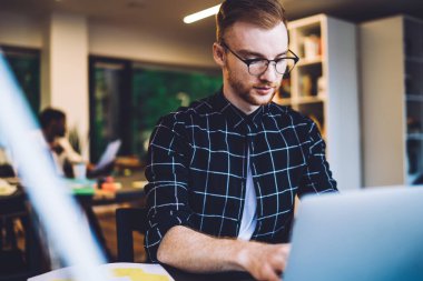 Optik gözlüklerdeki yetenekli yazılım geliştirici, içerideki yüksek hızlı internet bağlantısını kullanarak modern dizüstü bilgisayardaki veritabanlarını güncellemek için program kodu yaratıyor.